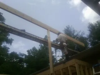 Carpenter setting a ridge beam over a new addition frame — Ice Dam Removal by Roofing Brothers in Coupeville