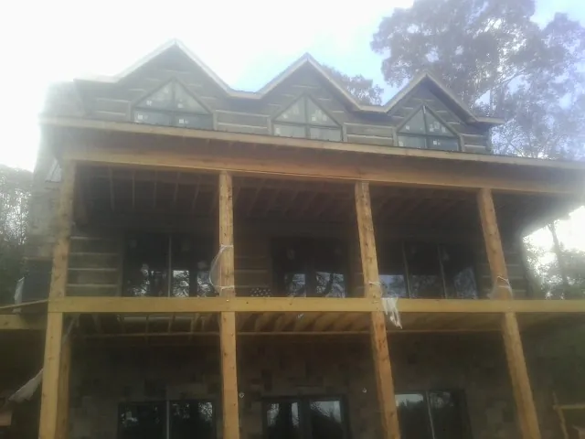 Dormers and porch framing on a large log home under construction — Roof Coating work by our crew in Coupeville